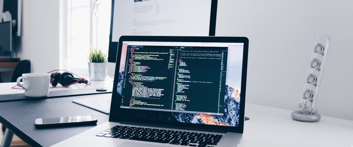 Developer webowy planujący prostą aplikację przy laptopie — analiza procesu klienta i przygotowanie briefu technicznego